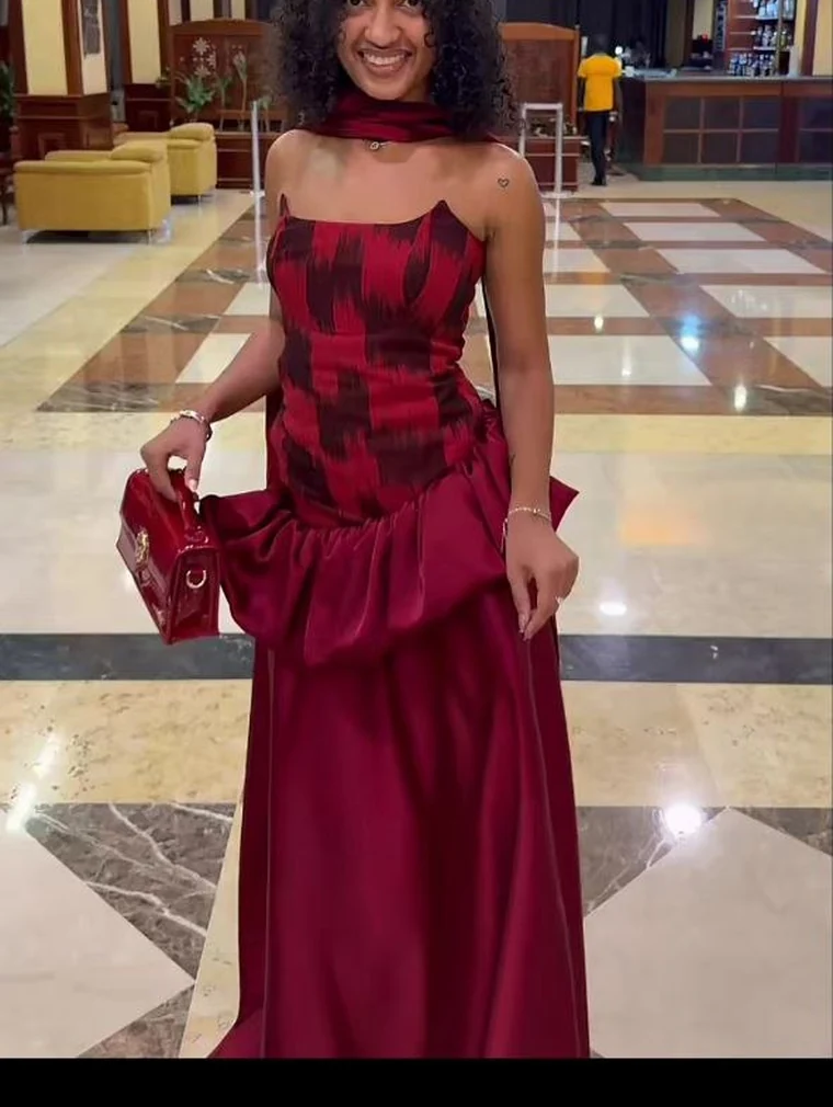 Cliente en robe bordeaux à basque, de face